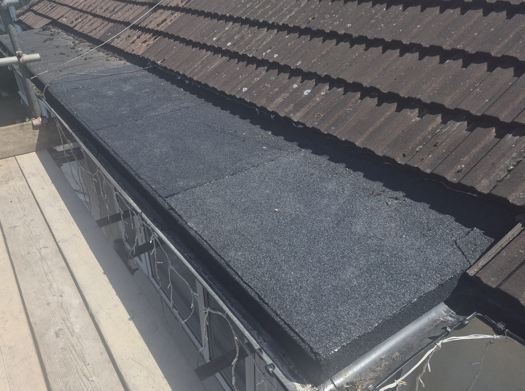 A newly finished flat felt roof laid to falls with fresh upstands